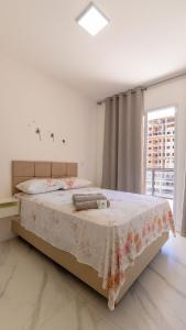 Un dormitorio con una cama con una manta floral. en 2Q Novinho! Na 2ª quadra do mar!, en Itaparica 31 fotos más