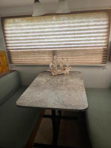a table with a boat on it in front of a window at Comfortable Guest RV With EV charger Semi Rural Area in Bodfish +1 photo