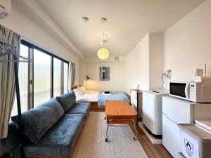 ein Wohnzimmer mit einer Couch und einem Bett in der Unterkunft トライアングル若宮201 trianglewakamiya in Tokio