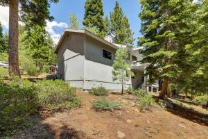 una casa blanca en el bosque con árboles en 3 Mi to Lake Tahoe Forest-View Sanctuary with Deck!, en Incline Village