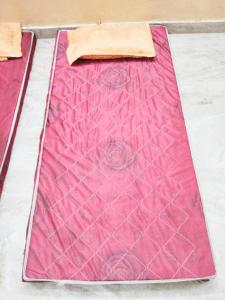 Una colcha rosa está colocada sobre una mesa. en Nidhivan Vatika Ashram, en Vrindāvan 15 fotos más