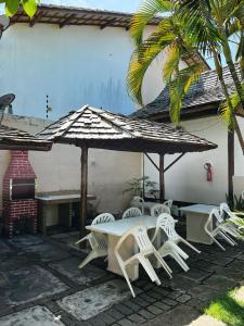 a group of tables and chairs under an umbrella at Pousada Mares de Stella in Salvador