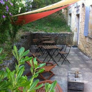 a patio with chairs and tables and a tent at L'Ombrière in Saint-Thomas-de-Cônac