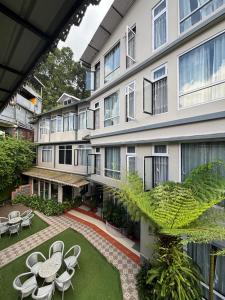 an apartment building with a courtyard with tables and chairs at Sood's Himalayan Vista in Kalimpong