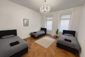 a bedroom with two beds and a chandelier at Offenbach 200 m2 9 Betten O2 EG in Offenbach