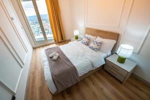 a bedroom with a bed and a large window at 32 Floor 1BR Apt with Spa & Fitness in Skopje