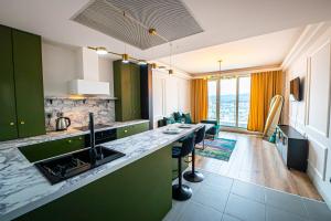 a kitchen with green cabinets and a counter top at 32 Floor 1BR Apt with Spa & Fitness in Skopje
