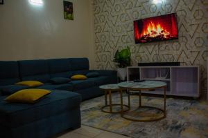 a living room with a blue couch and a fireplace at Kings 1 Bedroom in Busia