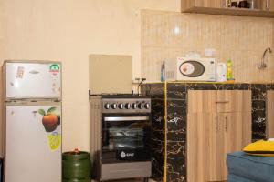 a kitchen with a stove and a refrigerator at Kings 1 Bedroom in Busia