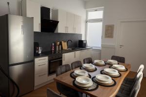 a kitchen with a wooden table with plates on it at Offenbach 200 m2 9 Betten O2 EG in Offenbach
