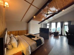 a bedroom with a bed and a flat screen tv at Sood's Himalayan Vista in Kalimpong