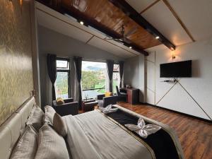 a living room with a couch and a tv at Sood's Himalayan Vista in Kalimpong