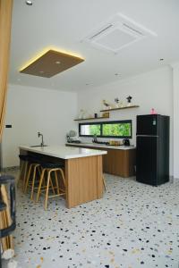 Una cocina con un refrigerador negro y una encimera. en Villa is close to nature, en Xóm Bình Nguyên