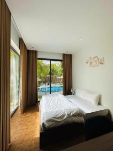 1 dormitorio con cama y piscina en Villa is close to nature, en Xóm Bình Nguyên
