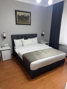une chambre avec un grand lit avec deux tables de nuit dans l'établissement gallelius, à Istanbul