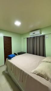 a bedroom with a large white bed with a window at Pousada Amorim in Frecheirinha