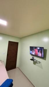 a room with a flat screen tv on a wall at Pousada Amorim in Frecheirinha