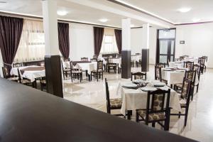 ein Esszimmer mit Tischen und Stühlen, weiße Tische und Stühle in der Unterkunft Hostel Karisma in Bacău