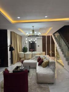 a living room with a couch and a staircase at RGS Luxury Residence in Ibadan +2 photos