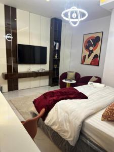 a bedroom with a large bed and a flat screen tv at RGS Luxury Residence in Ibadan