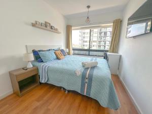 a bedroom with a bed with a blue blanket and a window at Nuevo departamento exclusivo a un paso de San Isidro in Lima +25 photos