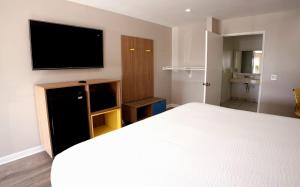 a bedroom with a bed and a flat screen tv at Days Inn by Wyndham Hemet in Hemet