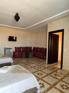 a hotel room with two beds and a couch at Mirleft Beach in Mirleft