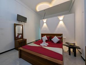 a bedroom with a bed and a mirror and a television at Zafara Resort in Udawalawe