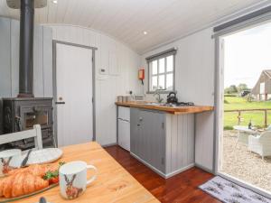a kitchen with a stove and a counter with a table at The Shepherds Hut in Nettleton