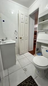a white bathroom with a toilet and a sink at Cabañas Coquimbo in Coquimbo