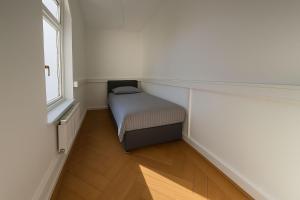 a small bed in a small room with a window at Offenbach 200 m2 9 Betten O2 EG in Offenbach +10 photos