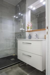 a bathroom with a white sink and a shower at Balcon des alizés pieds dans l'eau in Le Gosier