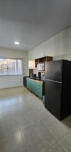 una cocina vacía con nevera negra en una habitación en Casa do Vale, en Ametista do Sul