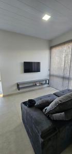 Una sala de estar con un sofá y un televisor de pantalla plana. en Casa do Vale, en Ametista do Sul