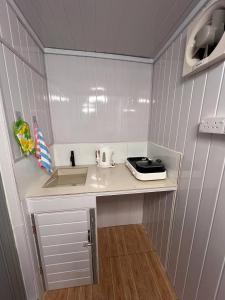 a small kitchen with a counter and a sink at Labuan homestay cabin sakura in Labuan