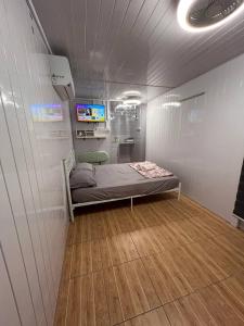 a small room with a bed and a tv in it at Labuan homestay cabin sakura in Labuan
