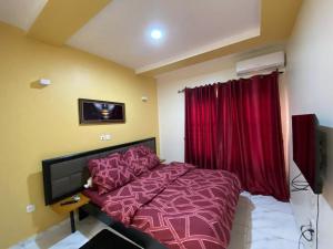 a bedroom with a purple bed and a television at Nouvelle route omnisports meublé in Yaoundé