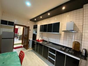 a kitchen with black and white tiled walls at Nouvelle route omnisports meublé in Yaoundé