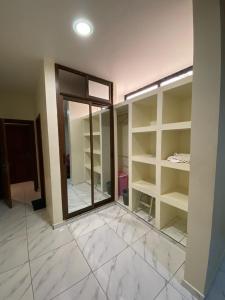 a walk in closet with a glass door and shelves at Nouvelle route omnisports meublé in Yaoundé +1 photo