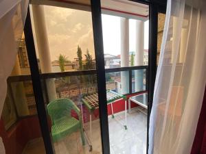 a balcony with a table and a green chair at Nouvelle route omnisports meublé in Yaoundé