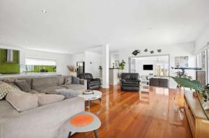 a living room with a couch and a table at Luxury 6 Bedroom Coastal Retreat with Spa & Ocean Views in Torquay