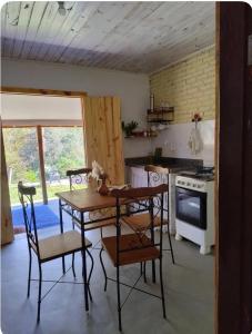a kitchen with a table and chairs and a stove at Recanto da paz in Monte Verde