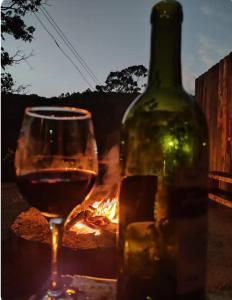 a glass of wine next to a bottle of wine at Recanto da paz in Monte Verde +10 photos
