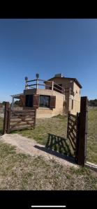 a wooden gate in front of a house at Cabaña El Balcón in La Estancia