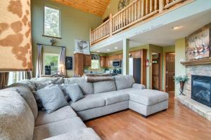 a living room with a couch and a fireplace at Hot Tub and Fire Pit! Lake-View Home in Blue Eye in Blue Eye