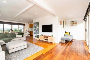 a living room with a couch and a tv at Absolute Waterfront Escape Deck & Games Room in Portarlington