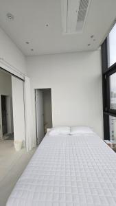 ソウルにあるSun&Uの窓のある白い部屋の白いベッド