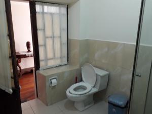 a bathroom with a white toilet and a window at Departamento a 1 cuadra de la Plaza Principal in Sucre