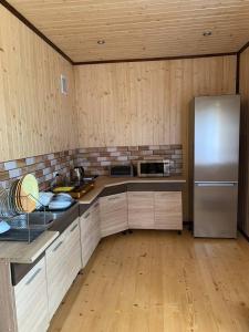 eine Küche mit einem Edelstahlkühlschrank und Holzwänden in der Unterkunft Армаден in Slawske