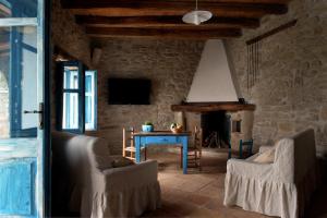a living room with a table and chairs and a fireplace at Domu Antiga in Gergei